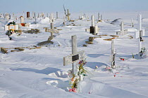 Wind blown snow around the graves in the cemetery of Igloolik. Nunavut, Canada, April 2008.