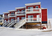 Modern Arctic homes built on piles driven into the permafrost. Iqaluit, Nunavut, Canada, April 2008.
