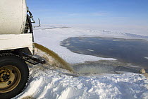 Raw sewage pouring from a tanker into a sewage lagoon, Igloolik Island, Nunavut, Canada, April 2008.