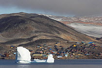 Iceberg floating by the Inuit village of Scoresbysund on the coast of Scoresbysund Fjord. East Greenland, September 2005.