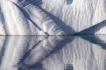 Sculptural shapes of an iceberg reflected in the water. East Greenland, September 2005.