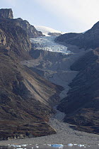Retreating valley glacier leaves signs of previous advances and retreats in its series of moraines. Rypefjord, East Greenland, September 2005.