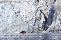 Ice cliffs of the Eielson glacier tower over a tourist zodiac. Rypefjord, East Greenland, September 2005.