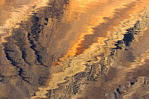 Reflections in water from mineral seepage on rocks. East Greenland, September 2005.