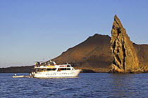 Dive boat by Pinnacle Rock, the eroded remains of a tuff cone, by the the volcano on Isla Bartolome. Galapagos, January 2005.
