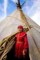 Khanty woman standing at the entrance to her family's tent in the Polar Ural Mountains, Yamal, Western Siberia, Russia, Summer 2007. Editorial use only.