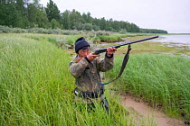 Selkup man shooting duck on Lake Puryakhar. Bistrinka, Purovsky, Yamal, Western Siberia, Russia, August 2008.