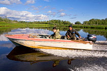 Selkup man and his son travelling by boat on the Puryakhar River near Bistrinka. Purovsky Region, Yamal, Western Siberia, Russia, August 2008. Editorial use only.