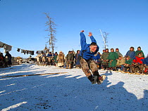 Nenets man competing in a long jump competition at a reindeer herders festival in the Yamal. Western Siberia, Russia, February 2009. Editorial use only.