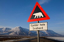 Road sign warning of polar bears, with the mountains of Adventdalen in the distance. Spitsbergen, Svalbard, Norway, June 2008.