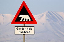 Road sign warning of polar bears, with the mountains of Adventdalen in the distance. Spitsbergen, Svalbard, Norway, June 2008.