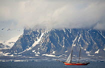 "The Noorderlicht", a two masted schooner used for arctic cruising, passing the mountains of West Spitsbergen, Svalbard, Norway, June 2008.