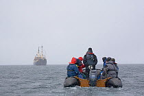 Zodiac returning passengers to "The Stockholm" in a snow flurry. Svalbard, Norway, June 2006.