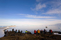 Group of tourists from "The Stockholm" enjoying the midnight sun on Karl XII Oya. Svalbard, Norway, June 2006.