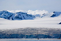 Yacht by a large glacier on the South West of Spitsbergen, Svalbard, Norway, June 2006.