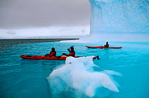 Eco tourists kayaking over sunken iceberg near Danco Island, Antarctica.