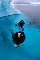 Divers close to a small iceberg while on a dive at Neko Harbour, Antarctica.