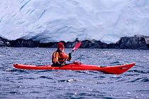 Eco tourist in a sea kayak paddling past a glacier near Port Lockroy. Antarctic Peninsula Editorial use only.