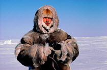 Arctic photographer Bryan Alexander holding his camera, dressed in caribou furs at minus 40 degrees. Nunuvut, Canada, 1987. Editorial use only.
