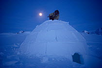 Inuit hunter at night finishing an Igloo he has built. Igloolik, Nunavut, Canada, 1990.