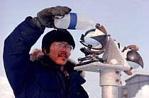Inuit technician cleaning a sunlight recorder at Igloolik Research Centre. Nunavut, Canada, 1990. Editorial use only.