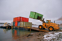 Containers of supplies being unloaded from a barge during sealift at Cape Dorset. Baffin Island, Nunavut, Canada, 2002.