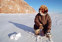 Inuit hunter from Arctic Bay filling a kettle with snow to make tea. Baffin Island, Nunavut, Canada, 2005.