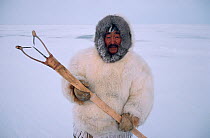 Inuit hunter in fox furs with Kakivak (Inuit fishing spear). Igloolik, Nunavut, Canada, 1993.