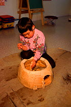 Inuit girl playing with model igloo in the Headstart early learning program. Igloolik, Nunavut, Canada, 1999.
