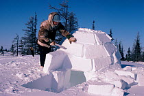 Man building igloo, Churchill, Manitoba, Canada, 2004.