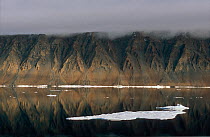 Dramatically eroded cliffs reflected in the waters of Hall Basin. Ellesmere Island, Nunavut, Canada.