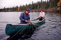 Cree trapper and his wife checking nets for fish on Lake Bourinot, Quebec, Canada, 1988.