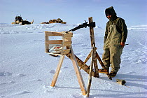 Hunter preparing set-gun trap to catch Polar bears (Ursus maritimus). These traps are now illegal. Scoresbysund, East Greenland, 1974.