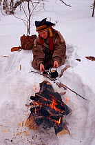 Lake Sami man cooking meat and coffee on fire. Inari, Finland, 1996.