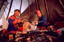 Sami herders cooking in their tent / lavvu during spring migration. North Norway, 1985.