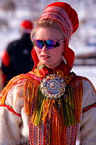 Sami girl wearing traditional clothes with modern sunglasses. Kautokeino, Norway, 1996.