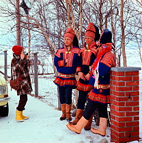 Tourist photographing group of Sami men in traditional costume. Kautokeino, Norway, 1972.