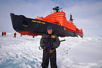 Safety guard watching for Polar bears while tourists from Russian icebreaker walk on sea ice. North Atlantic, 1998.