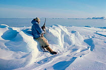 Inuit man hunting seals with rifle at floe edge in Melville Bay, Northwest Greenland, 1980.