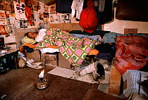 Inuk asleep in hut with stove for warmth. Northwest Greenland, 1980.