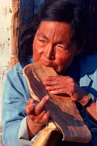 Inuit woman chewing sealskin sole to soften it for making kamik (boots). Northwest Greenland, 1980.