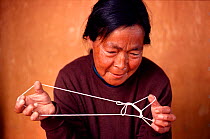 Inuit woman with string puzzle depicting story of fox. Greenland, 1980.