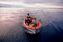 Inuit hunters returning from autumn hunt in their boat. Moriussaq, Greenland, 1987.