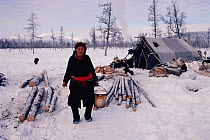 Chukchi woman carrying bucket of snow to melt for water at camp in the Oloy Valley. Chukotka, Siberia, Russia, 1994.
