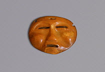 Miniature ritual mask carved from Walrus ivory (circa 1000 BC - 1000 AD) Bering Strait, Chukotka, Siberia, Russia.