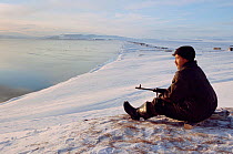 Young Chukchi hunter waiting near shoreline at Dezhnovka for seals to surface. Uelen, Chukotka, Siberia, Russia, 2004.