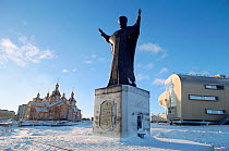 Statue of St Nicholas overlooking harbour in Anadyr, with new church and culture centre beyond. Chukotka, Siberia, Russia, 2004. Editorial use only.