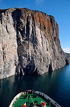 Bow of icebreaker "Kapitan Dranitsyn" approaching Rubini Rock bird cliffs. Hooker Island, Franz Josef Land, Russia, 2004.