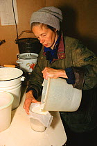Woman filtering Moose milk at Sumarokova Moose Farm. Kostroma, Russia, 2002.