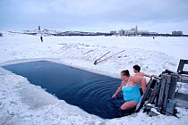 Bathers swimming during February in hole in ice covering Lake Semyonovskaya. Murmansk, Northwest Russia, 2005.